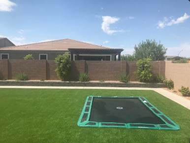 Rear view of backyard in-ground trampoline