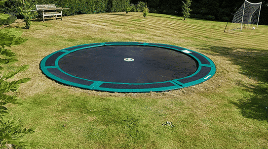 Round green in-ground trampoline installed