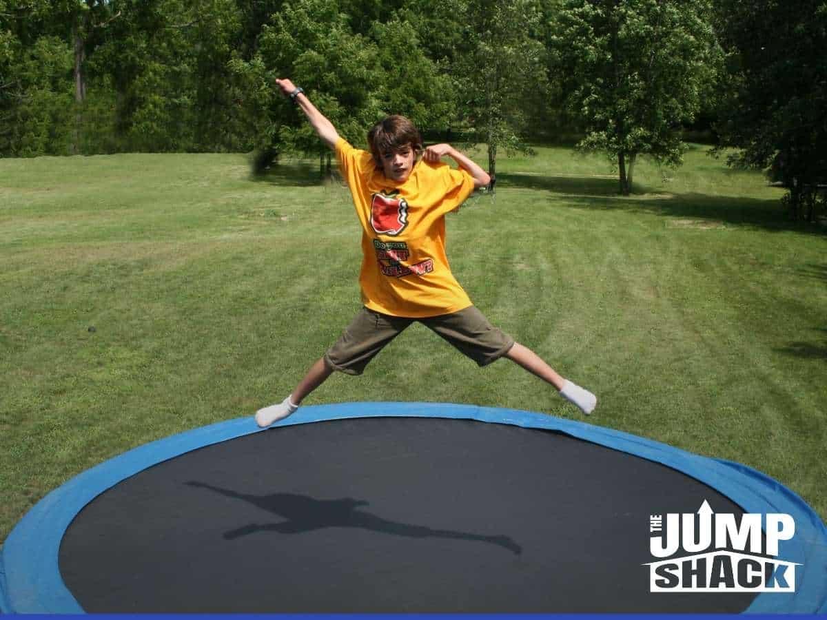 A Kid jumping in a in-ground trampoline 