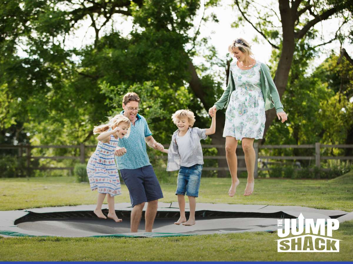 A family enjoying a [Gilbert In-ground trampoline] in their backyard.