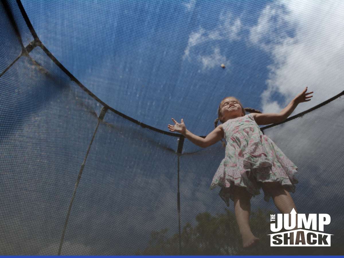 Young girl enjoying a trampoline with safety features like a protective net