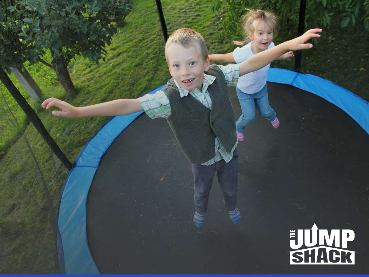 Children joyfully bouncing on an in-ground trampoline, demonstrating the importance of regular checks for safety.