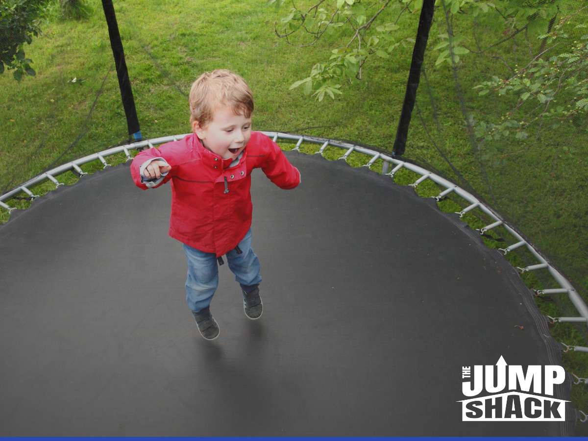 Child jumping on an outdoor trampoline this winter, enjoying safe playtime